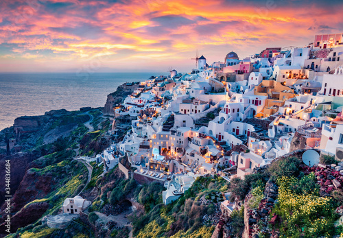 Fototapeta Naklejka Na Ścianę i Meble -  Astonishing evening view of Santorini island. Magnificent summer sunset on famous Greek resort Oia, Greece, Europe. Fantastic seascape of Mediterranena sea. Traveling concept background.