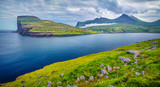 Dramatic summer view of Eidi village. Rainy morning scene of Eysturoy island. Green landscape of Faroe Islands, Denmark, Europe. Beauty of nature concept background.