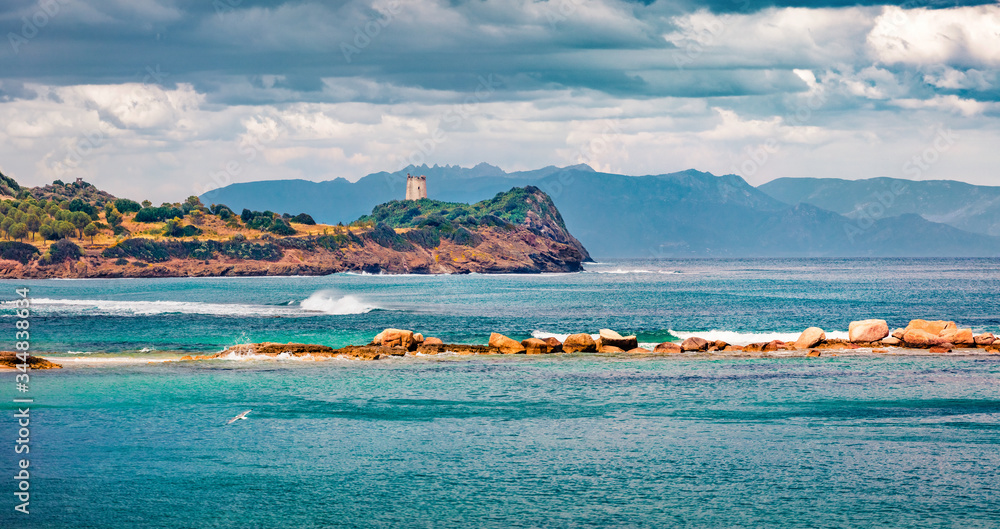 Panoramic morning view of Torre di San Macario tower from Nora beach. Colorful summer scene of Sardinia island, Italy, Europe. Bright seascape of Mediterranean sea. Traveling concept background.
