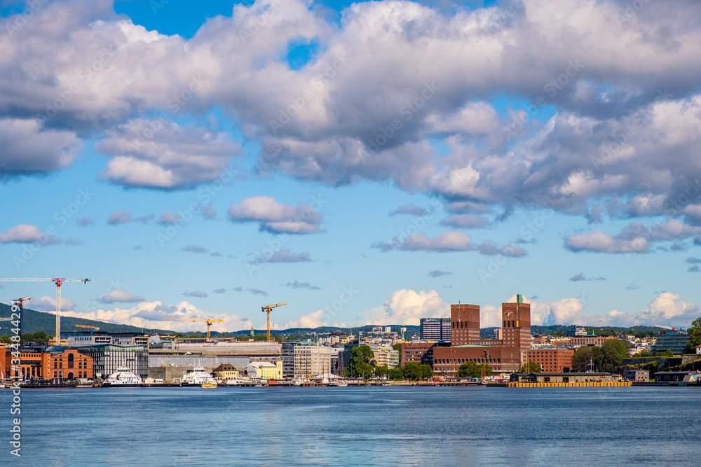 Oslo, Norway - Panoramic view of Oslo waterfront with City Hall, Aker Brygge and Tjuvholmen borough at Pipervika harbor Oslo, Norway - Panoramic view of Oslo waterfront with City Hall, Aker Brygge and Tjuvholmen borough at Pipervika harbor