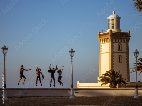 Four people jumping on the parapet of Cape Spartel lighthouse