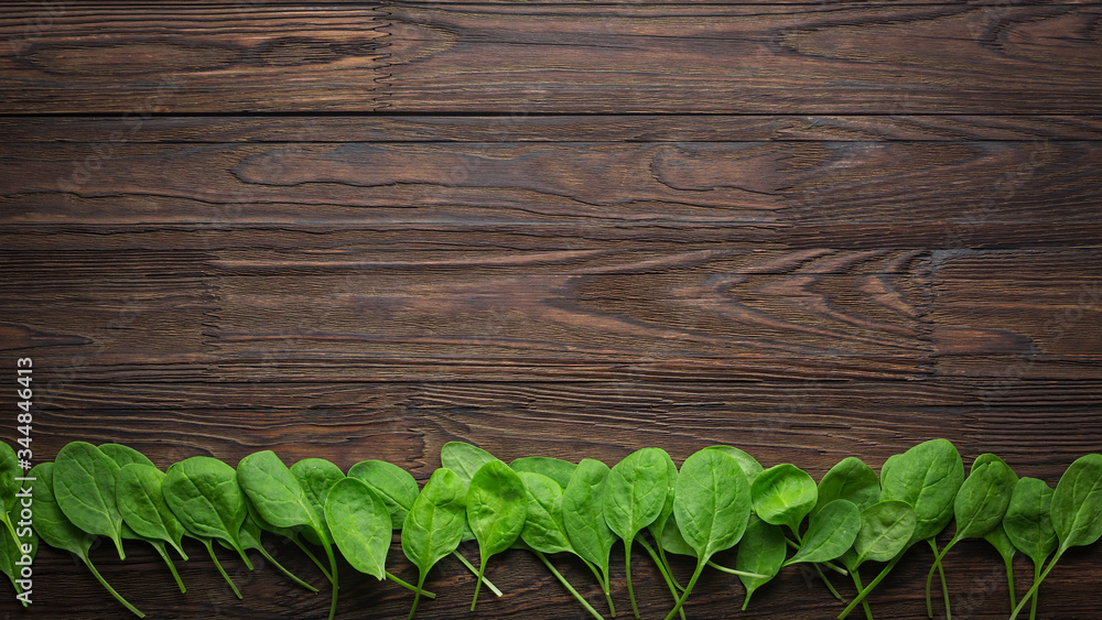 Wooden background with baby spinach leaves. Copy space. healthy eating concept Wooden background with baby spinach leaves. Copy space. healthy eating concept