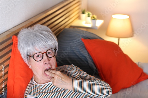 Picky senior woman gagging in bed
