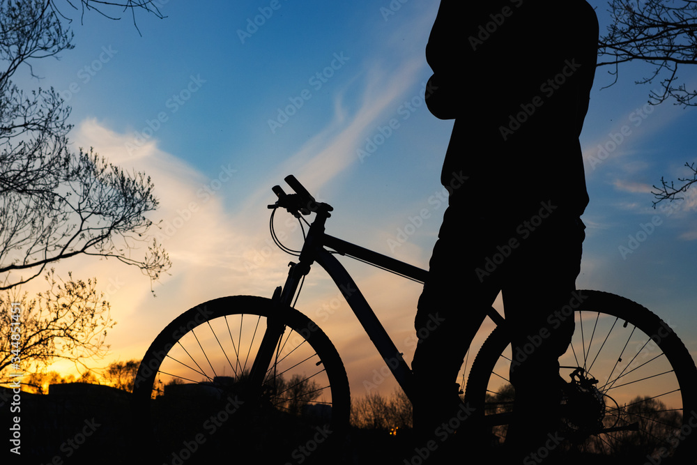 Obraz premium Silhouette of a cyclist at sunset against the sky