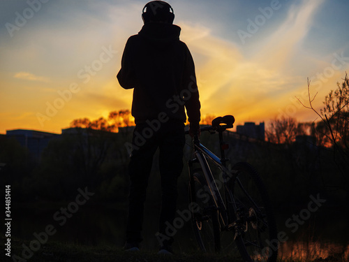 Silhouette of a cyclist at sunset against the sky