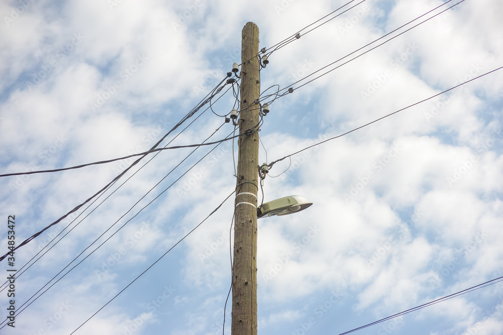 Electric wooden pole with lamp and electricity cables hanging on Electric wooden pole with lamp and electricity cables hanging on