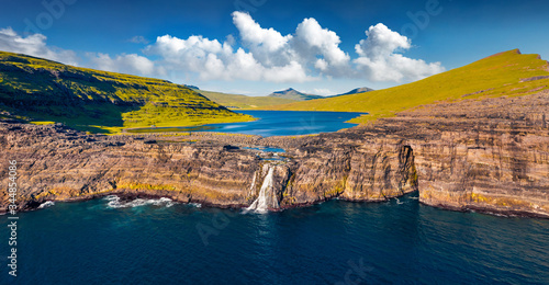 View from flying drone. Panoramic morning view of Bosdalafossur waterfall, that falls directly into the ocean. Exciting summer scene of Sorvagsvatn lake, Vagar, Faroe Islands, Denmark, Europe.