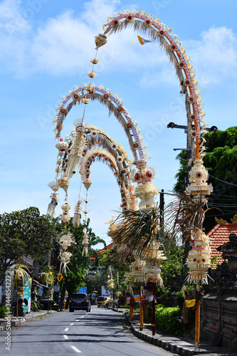 A road in Bali with a blue sky background and penjor lined up © Mitsuru Kumazawa