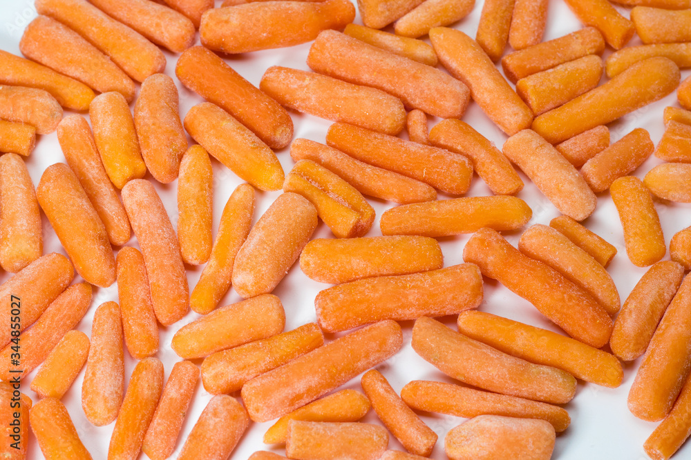 Close up of frozen baby carrots on white background Close up of frozen baby carrots on white background