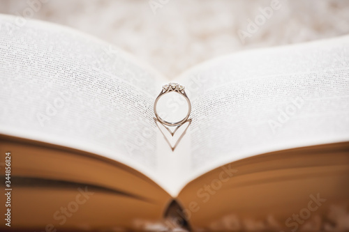wedding ring reflecting heart shadow on to a book. photo
