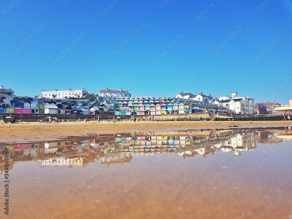 Stock photo of a colourful view of the sea shore of the Essex small town Walton-on-the-Naze reflected in the sea water, with copy space.