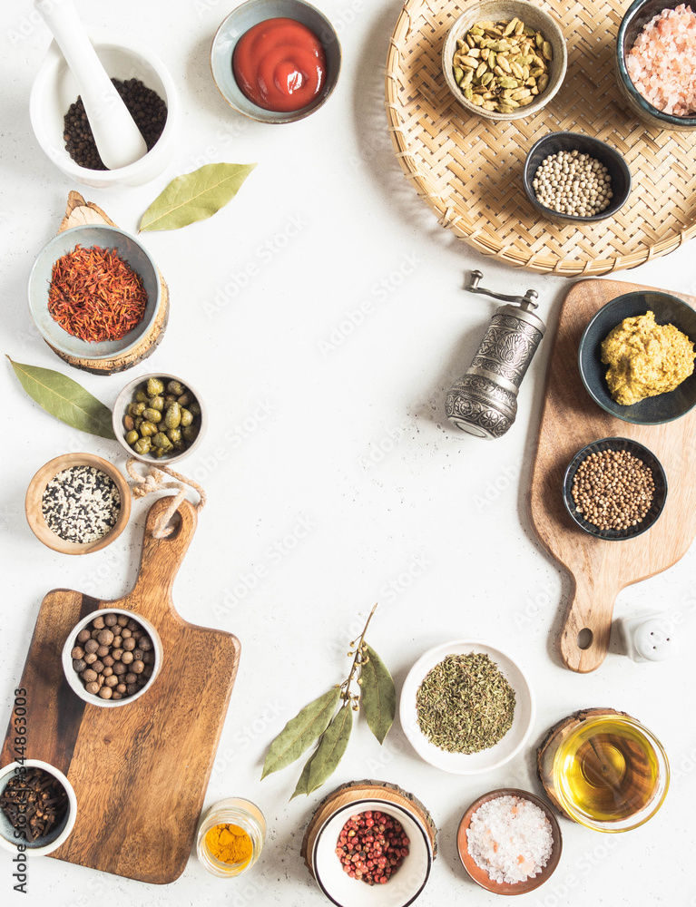 Frame of various dry spices and sauces on a light background. Flat lay of small bowls with dijon mustard, olive oil, ketchup, capers and spices. Frame of various dry spices and sauces on a light background. Flat lay of small bowls with dijon mustard, olive oil, ketchup, capers and spices.