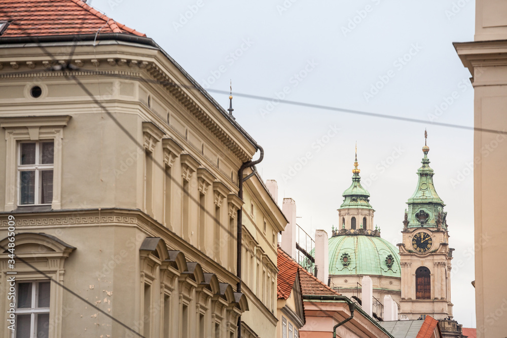St Nicholas Church, also called Kostel Svateho Mikulase, in Prague, Czech Republic, with its iconic dome seen from nearby streets with typical baroque facade. It's one of main landmarks.
