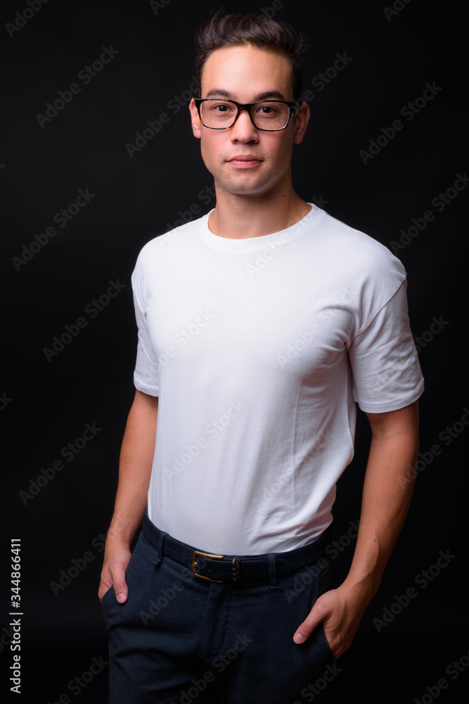 Young handsome multi ethnic man against black background Young handsome multi ethnic man against black background