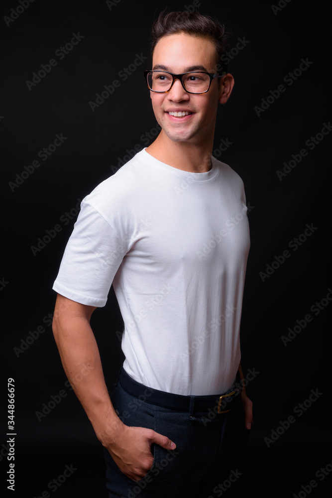 Young handsome multi ethnic man against black background Young handsome multi ethnic man against black background
