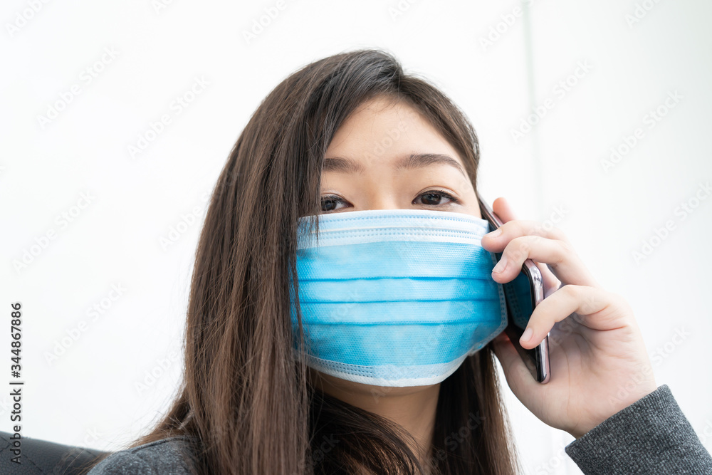 Woman long hair wearing protective mask holding and using mobile phone Woman long hair wearing protective mask holding and using mobile phone