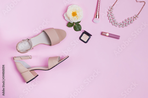 Composition with women's sandals and accessories on pink background.