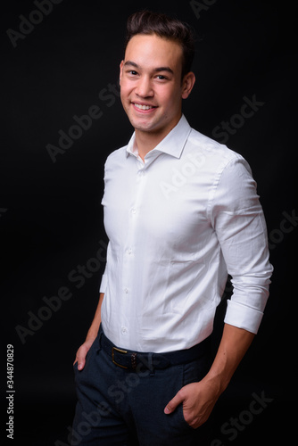 Young handsome multi ethnic businessman against black background © Ranta Images