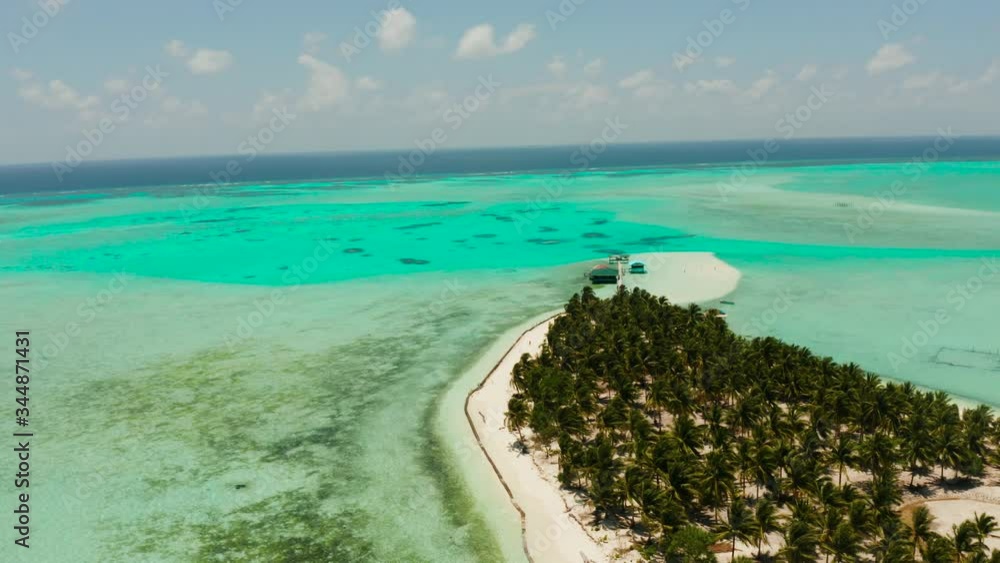Tropical island in the ocean with palm trees on white sand beach. Onok Island, Balabac, Philippines. Summer and travel vacation concept Tropical island in the ocean with palm trees on white sand beach. Onok Island, Balabac, Philippines. Summer and travel vacation concept