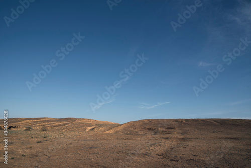 A hill in the steppe under a blue sky