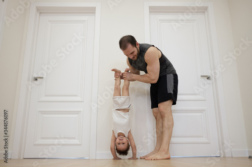 COVID-19 Shutdown. Father and son having fun exercising together and staying physically active at home during coronavirus quarantine. Stay home, Exercise, Health Self-care for Coronavirus isolation..