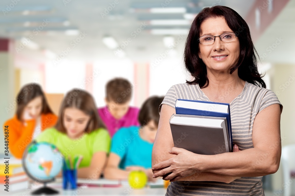 Smile woman teacher with books on class background Smile woman teacher with books on class background