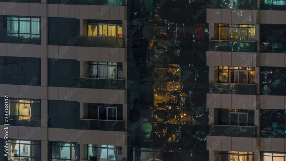 Night view of exterior apartment building timelapse. High rise skyscraper with blinking lights in windows with people moving inside Night view of exterior apartment building timelapse. High rise skyscraper with blinking lights in windows with people moving inside