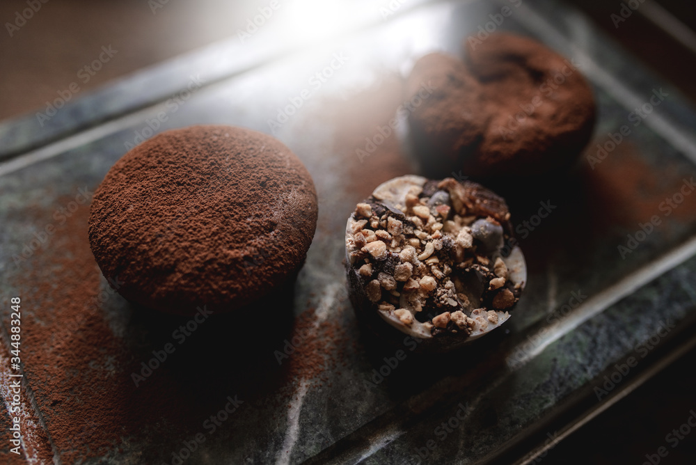 Close up of dark chocolate cake dessert with nuts ice cream served on a soap stone. Close up of dark chocolate cake dessert with nuts ice cream served on a soap stone.