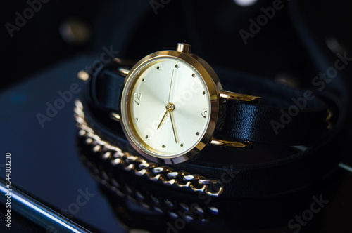 Watch with a leather strap and chain round dial in black and blue colors with space for text background