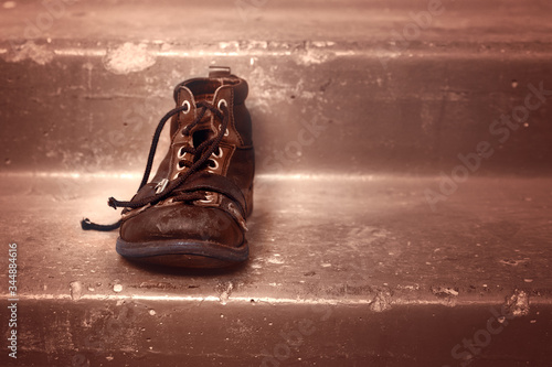 One old thrown shoe on the stairs. The concept of old age and loneliness. Copy Space. photo