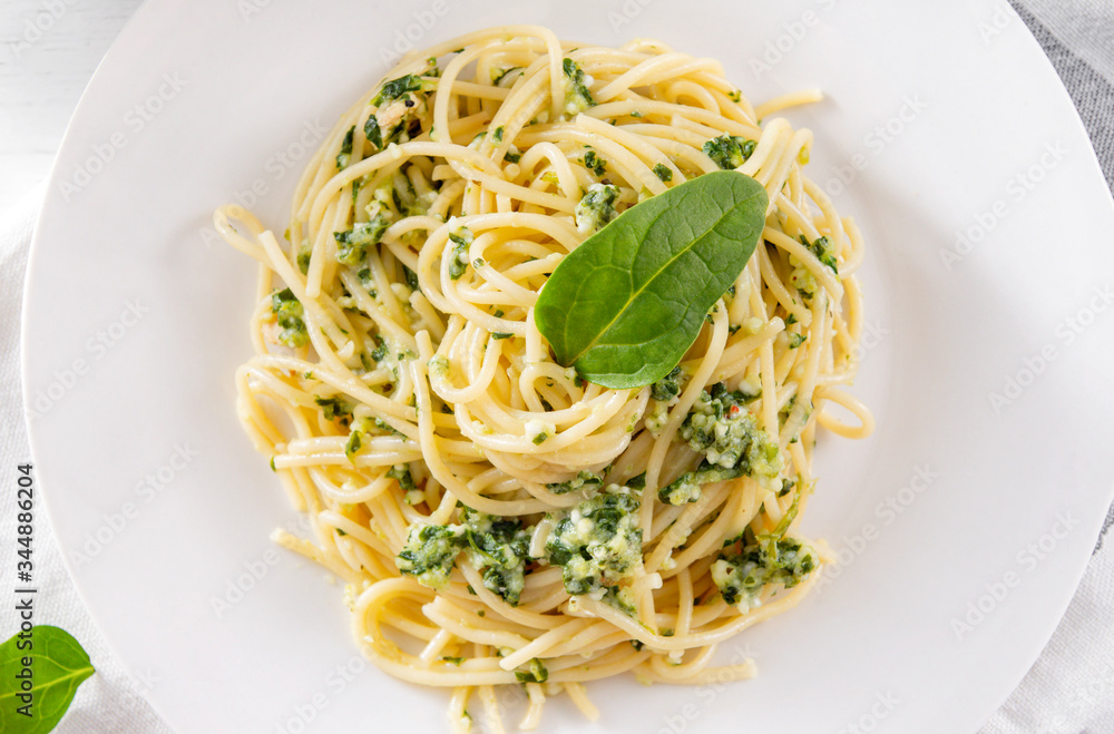 pasta with spinach and cheese on a white plate close up, pasta with spinach and cheese on a white plate close up,