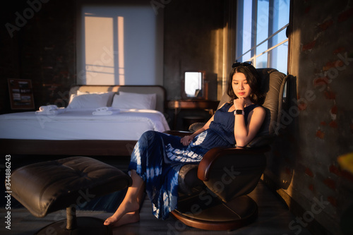 Beautiful Asian woman sitting on chair in the room.