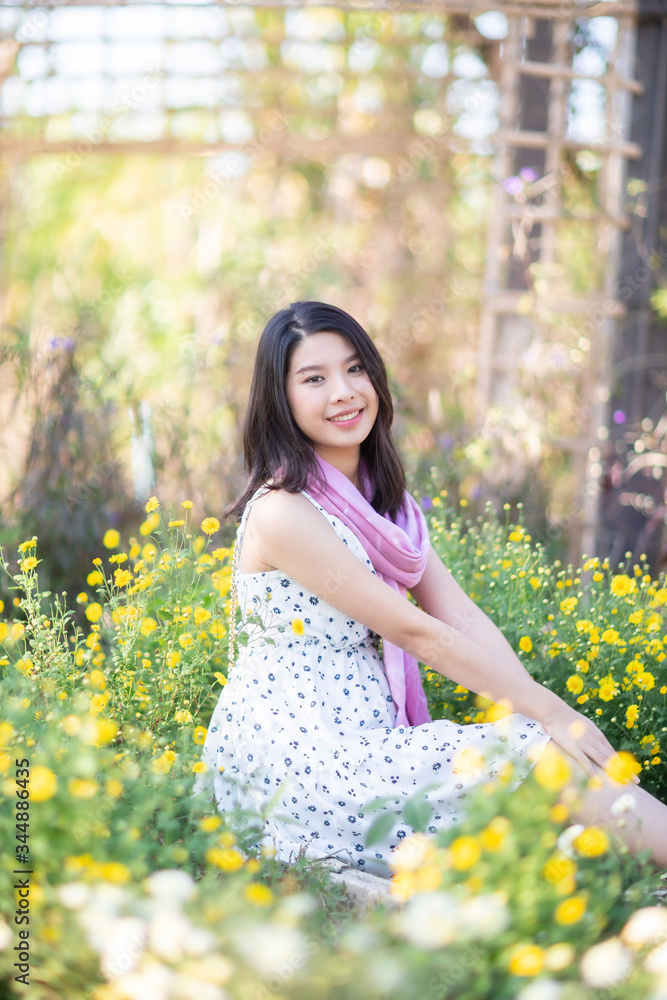 Beautiful Asian woman sitting in flowers garden. Beautiful Asian woman sitting in flowers garden.