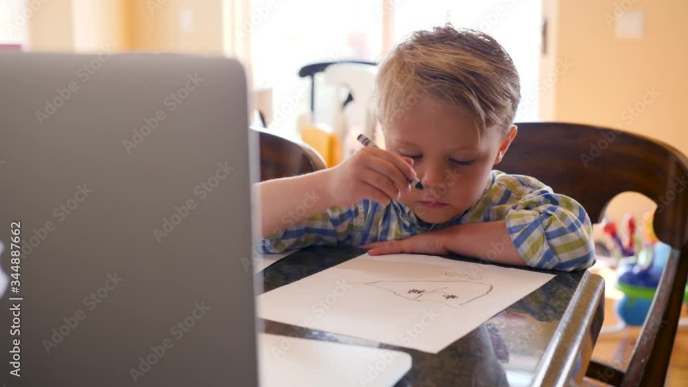 Little Boy Drawing While Using A Laptop. Hand held close up video as little boy is looking to the laptop and draws a picture with the pencil. Little Boy Drawing While Using A Laptop. Hand held close up video as little boy is looking to the laptop and draws a picture with the pencil.