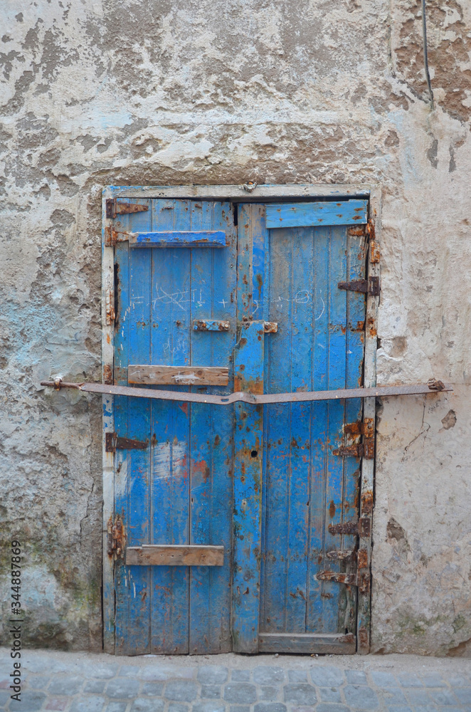 Vintage locked wooden blue door at fishing village Essaouira .