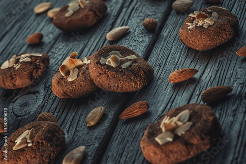 delicious and crunchy cookies with almond and chocolate on dark wooden background