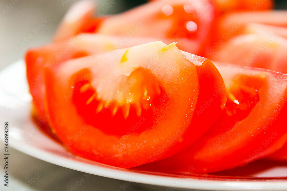 Tomatoes cut into slices on a plate. Healthy snack.