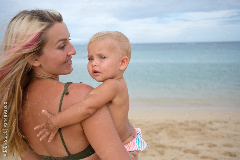 Beautiful portrait of mother and daughter on the sea and beach background.