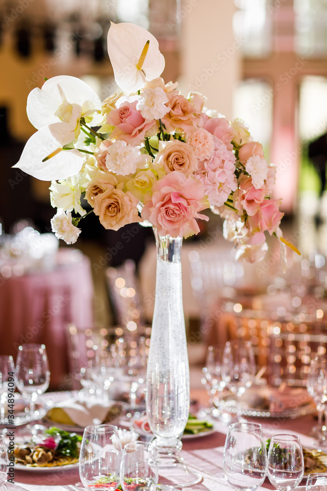 Banquet table decorated with cotton and flower composition, glasses and plates are placed on table Banquet table decorated with cotton and flower composition, glasses and plates are placed on table