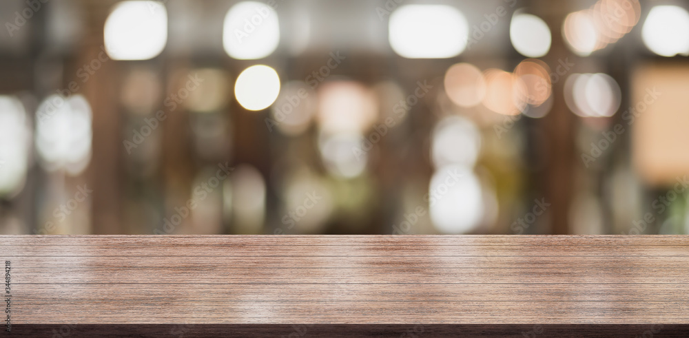 Empty wooden table top with lights bokeh on blur restaurant background. Empty wooden table top with lights bokeh on blur restaurant background.