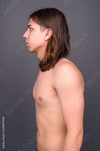 Young handsome androgynous man with long hair shirtless