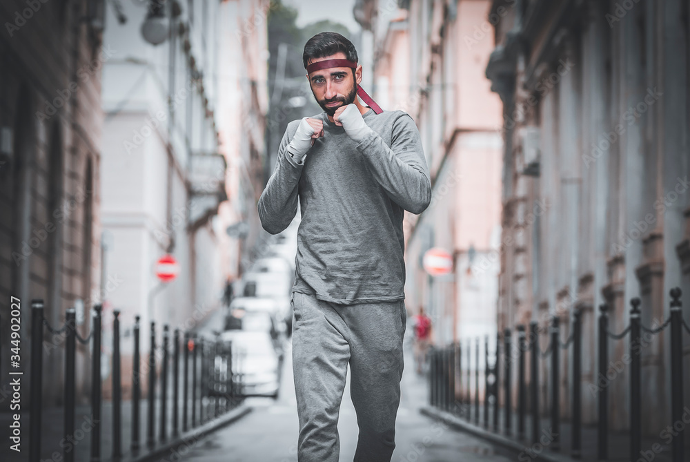 Athlete runs through the streets of the city. Training with your fists. Athlete runs through the streets of the city. Training with your fists.