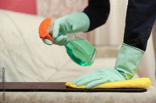 cleaner's hands in rubber gloves doing disinfection cleaning with detergent spray and rag. preventive measures against virus infection