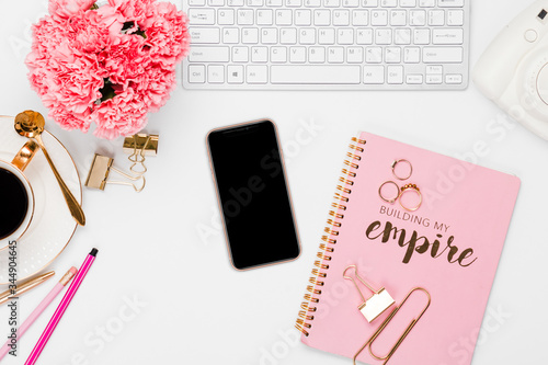 Pink office details with electronics and desk accessories in a white background