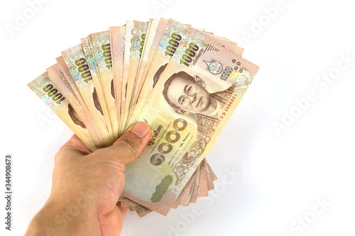 Many 1,000 baht banknotes in the hand On a white background