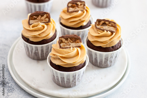 Cuadro en lienzo Homemade chocolate dough cupcakes with peanut butter frosting and snickers bites