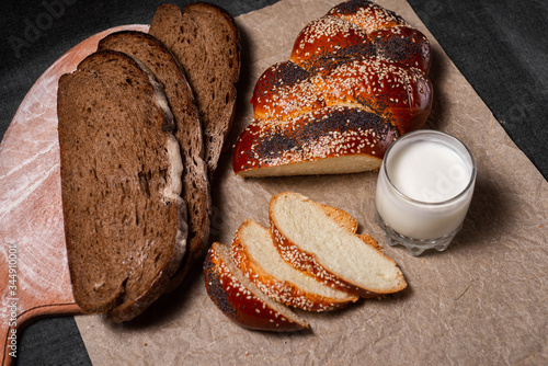 Baking, rolls and bread on a wooden board.
Photo of food on a dark background.