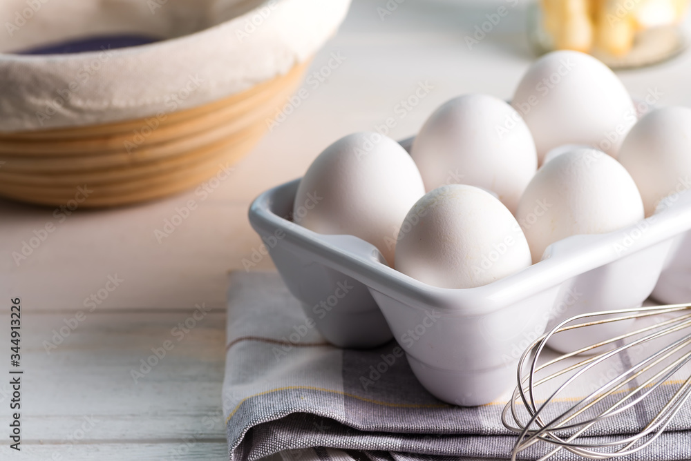 Ceramic container with natural organic farm eggs on a blurred kitchen background. Ceramic container with natural organic farm eggs on a blurred kitchen background.