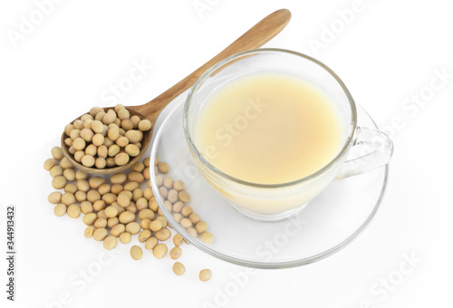 Soymilk in glass with soy beans in wooden spoon isolated on white backgroun  health care concept
