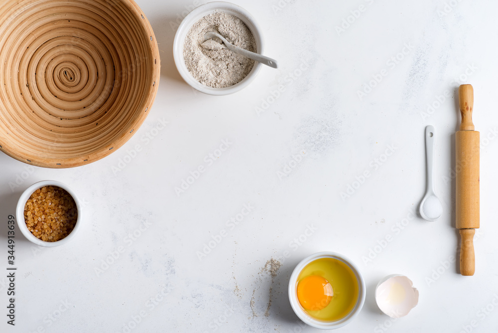 Fototapeta premium Homemade production of fresh healthy bread of other pastry from natural ingredients on a light grey background.